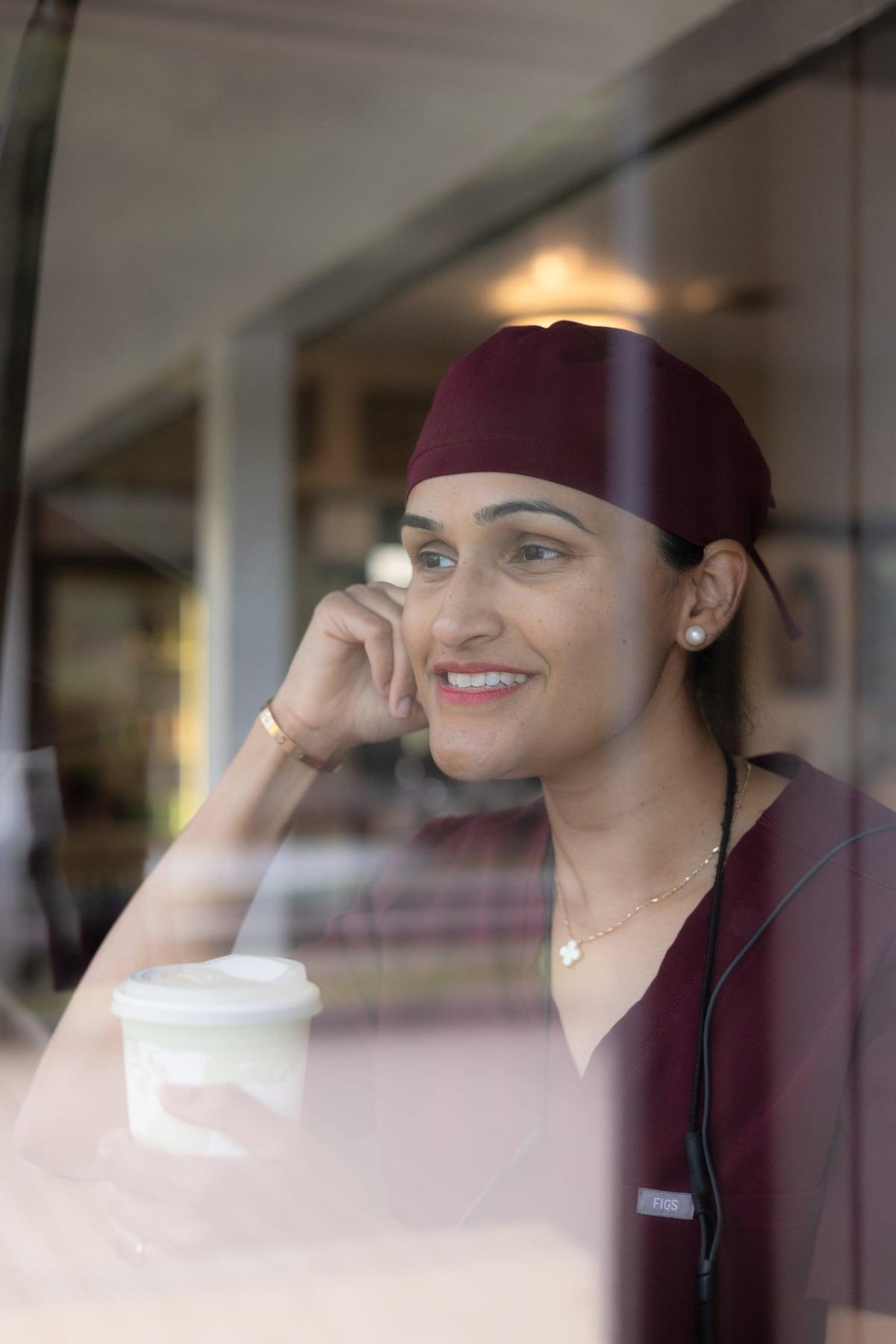 Dr. Sampada Deshpande smiling in burgundy dental scrubs